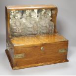A late Victorian oak and electroplate mounted three decanter tantalus, with wine labels 'B', 'W' and