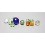 A large Victorian glass marble and eleven smaller marbles