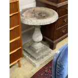 A circular reconstituted stone bird bath on stepped square plinth, 67cm diameter, height 80cm