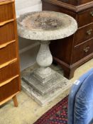 A circular reconstituted stone bird bath on stepped square plinth, 67cm diameter, height 80cm