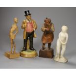 A German pottery figure and two alpine carved wood figures and a soapstone figure, tallest 21cm