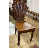 A Victorian oak hall chair, the fluted fan-carved back centered with Tudor style rose, over tapering