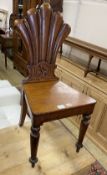 A Victorian oak hall chair, the fluted fan-carved back centered with Tudor style rose, over tapering