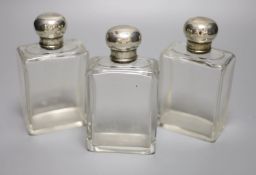 A set of three George V silver topped glass toilet jars, London, 1912, 13.2cm, with engraved