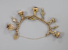 A 9ct. charm bracelet hung with nine assorted gold and gold plated seals, watch keys, etc. gross