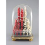 A set of 19th century Cantonese carved and red stained ivory chess pieces under dome, white king