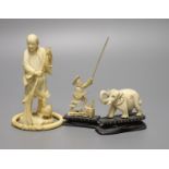 A Japanese carved ivory figure, male with brush, Meiji period, an elephant, a fisherman and a