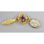 A Victorian yellow metal and amethyst set scroll brooch, 45mm, gross 10.6 grams, a Victorian 15ct