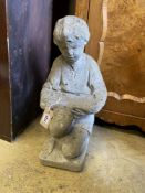 A reconstituted stone garden ornament of a boy reading, height 50cm