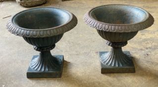 A pair of Victorian cast iron campana shaped garden urns, diameter 32cm, height 27cm