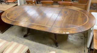 An 18th century style cross banded oak D end twin pillar extending dining table, 284cm extended, two