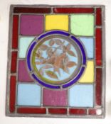 A rectangular stained glass and lead panel, 'bird' roundel to centre, 35 x 30cm
