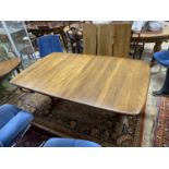 An Ercol Golden Dawn elm extending dining table, length 250cm extended (three spare leaves), width