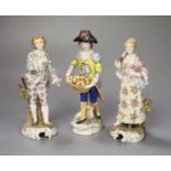 A pair of Continental figurines and a fruit seller, tallest 17cm