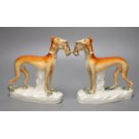 A pair of 19th century Staffordshire pottery greyhound figures, each with prey, 19cm high, 16.5cm