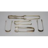 Six pairs of assorted 18th and 19th century silver sugar tongs including one bright cut engraved