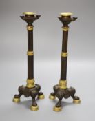 A pair of 19th century French bronze and ormolu mounted candlesticks with fluted stems, on tripod