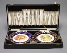 A cased dessert service containing six gilt and fruit decorated plates and a set of knives and