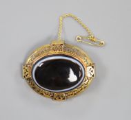 A Victorian pierced yellow metal and banded agate set oval mourning brooch, with plaited hair en