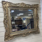 A rectangular carved and pierced framed gilt wall mirror in the rococo style, stepped and moulded