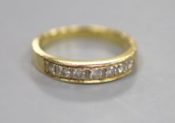 A modern 750 yellow metal and channel set seven stone diamond half hoop ring, size N, gross 3.9