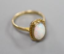 A 9ct and oval white opal set dress ring, size K, gross 2.6 grams.