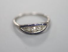 A 1920's white metal and graduated five stone diamond set curved navette shaped ring, with