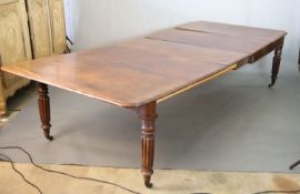 A Victorian mahogany extending dining table, with four leaves, on turned and fluted legs fitted
