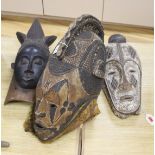 An African helmet mask, possibly Kaba, and two others
