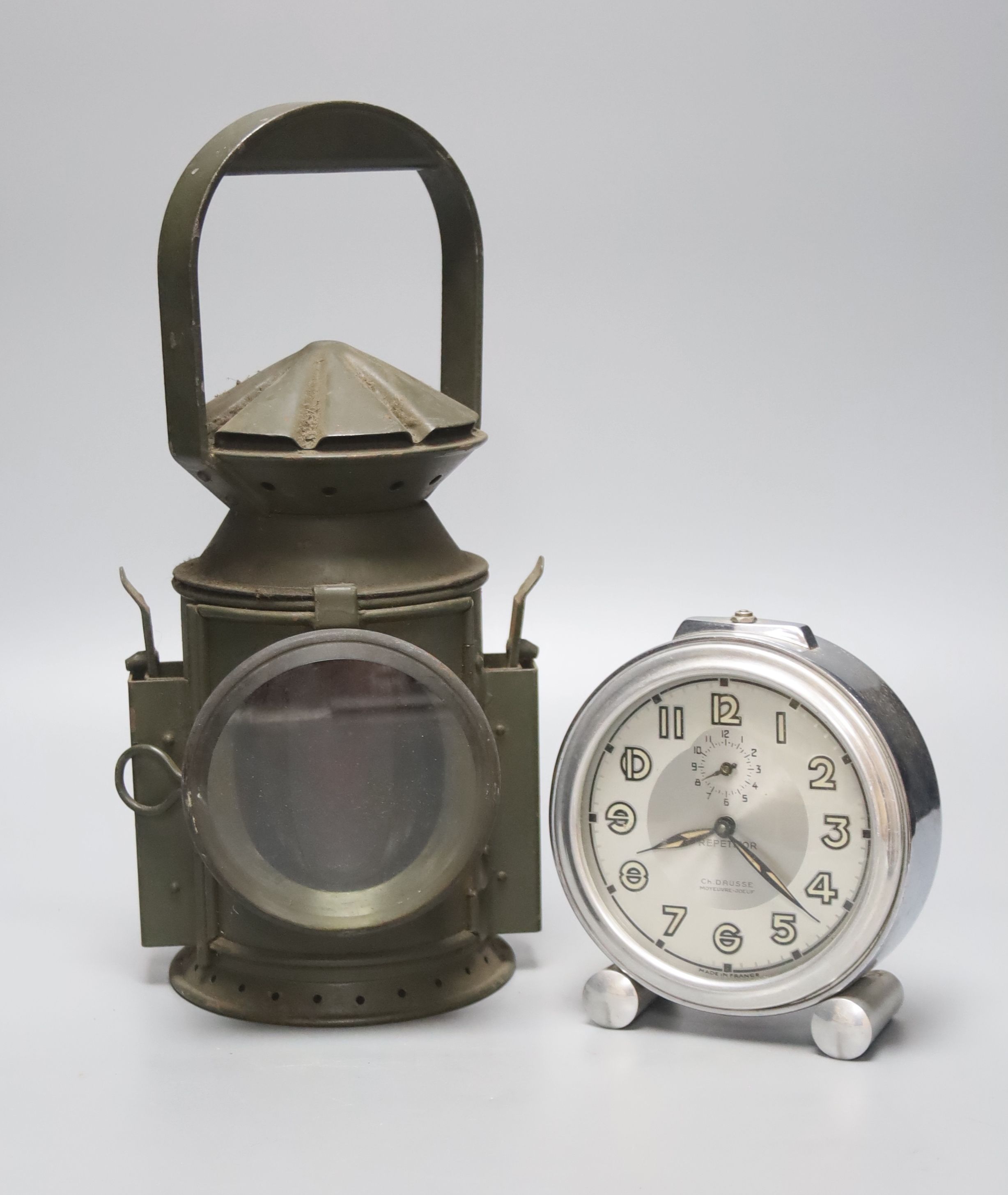 A green painted railway lantern, 30cm high, together with a French chrome cased alarm clock, the