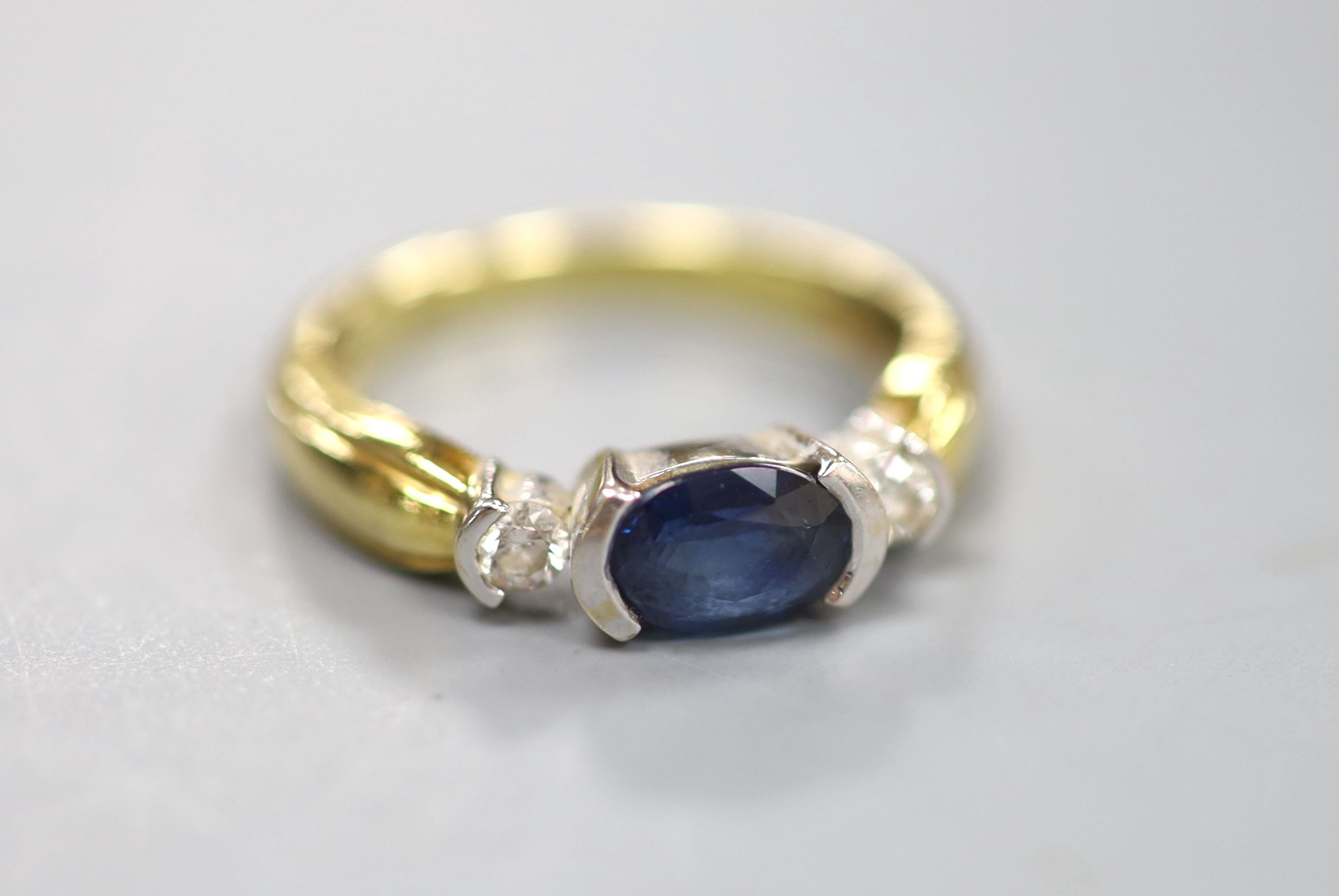 A modern 18ct, sapphire and diamond set three stone ring, size M, gross 4.1 grams.