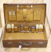 Finnigan's of Manchester. A leather case fitted with silver mounted and ivory dressing accessories