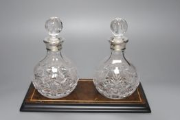 A pair of silver collared decanters, on stand