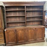 A Victorian mahogany library bookcase, the open shelves over an enclosed four door base, length