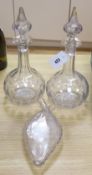 A pair of panel cut clear glass decanters , 36cm high and a wheel engraved glass flask, dated