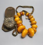 An early 20th century Tibetan and white metal portable shrine and a simulated amber Buddhist rosary
