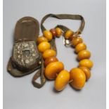 An early 20th century Tibetan and white metal portable shrine and a simulated amber Buddhist rosary