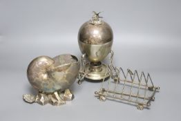An electroplate nautilus shell spoon warmer, an egg coddler and a folding toast rack, height 23cm
