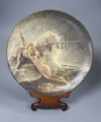 A Watcombe Torquay outside decorated terracotta plate 'Burdens of the Sea', on stand, diameter 27cm