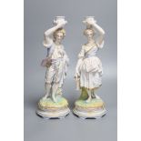 A pair of French export bisque porcelain figural candlesticks, stamped Chantilly, height 34cm (one