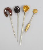 Four assorted early 20th century gem set stick pins including 15ct and diamond chip.