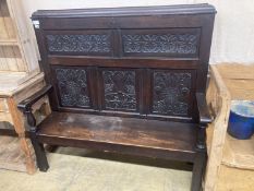 A 19th century oak settle incorporating 17th century panels, width 137cm, depth 44cm, height 131cm