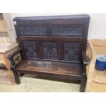 A 19th century oak settle incorporating 17th century panels, width 137cm, depth 44cm, height 131cm