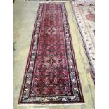 A Caucasian design red ground runner, 310 x 86cm