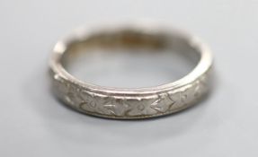An engraved white metal(stamped platinum) wedding band, size L, 4.9 grams.CONDITION: Slight wear