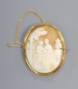 A yellow metal mounted oval cameo shell brooch, carved with scene of two ladies in a garden, 55mm,