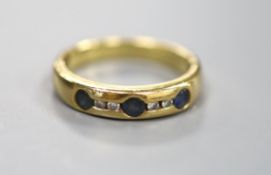 A modern 750 yellow metal, sapphire and diamond set half hoop ring, size N/O, gross 5.6 grams.