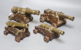 Four bronze or brass model cannons, with associated wood carriages, 20th century, barrel lengths