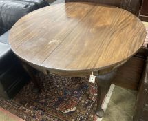 A 1920's circular mahogany extending dining table with three leaves and handle, length approx. 230cm