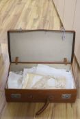 A brown leather suitcase of table linens